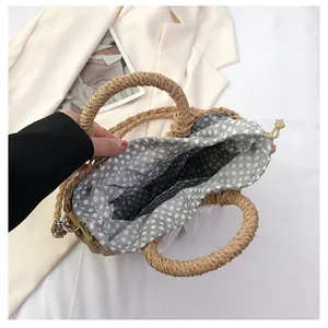 Détail du sac en paille montrant la doublure à pois et la fermeture par cordon serrage