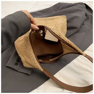 Dettaglio della borsa in paglia intrecciata con finiture in pelle marrone e tasca interna