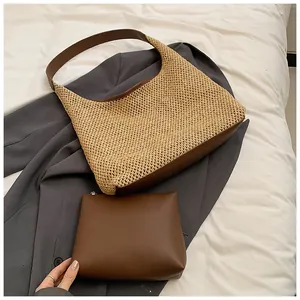 Dettaglio della borsa tote in paglia intrecciata con finiture in pelle marrone e pochette