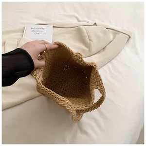 Detail shot showing the spacious interior and textured weave of the khaki straw bucket bag