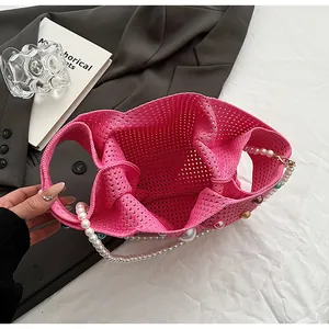 Detailaufnahme der rosa Häkeltasche mit einem eleganten Griff aus großen Perlenperlen