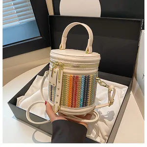 Detail of a chic bucket bag with colorful V-pattern weave on premium cream leather