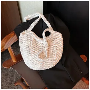 Detail of white handmade crochet tote bag with retro diamond knit texture on black blazer