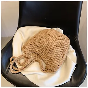 Detail shot of khaki woven bucket bag texture on silk fabric and leather chair