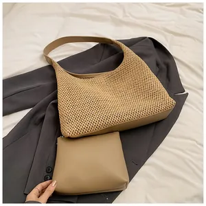 Dettaglio borsa tote in paglia intrecciata con pochette interna su sfondo scuro