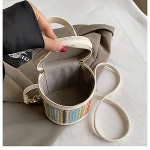 Detail view of woven rainbow bucket bag with beige leather strap and interior lining