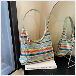 Nahaufnahme der böhmischen Regenbogen-Stricktasche mit grünem Lederriemen und Perlenanhänger