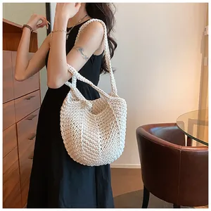 Close-up detail of white hand-woven crochet shoulder bag with rich bohemian knit texture