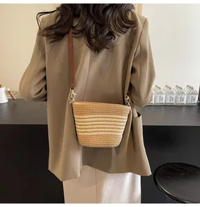 Detailed view of woven crossbody bag with gradient stripes and premium leather strap