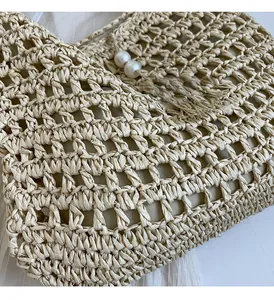 Détail du sac bohème en paille avec tissage en maille et accents de perles chic
