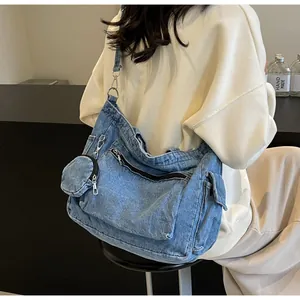 Dettaglio della borsa tote in denim blu con tasca a zip e portamonete rotondo abbinato