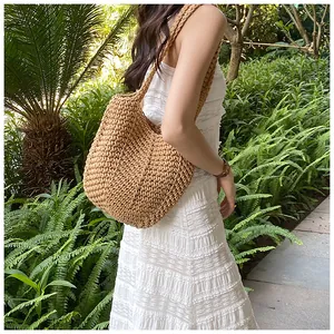 Detail of bohemian woven shoulder bag featuring textured crochet patterns in straw color