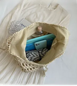 Détail de l'intérieur spacieux avec doublure et poche zippée d'un sac de plage en paille