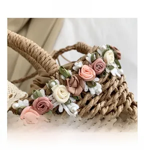 Detail of straw bag with fabric roses, white lace trim and imitation pearl accents