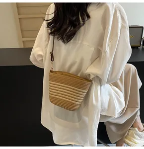 Detail of woven crossbody bag showing gradient stripes and gold metal hardware