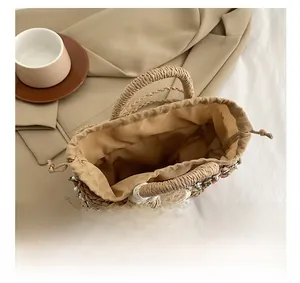 Top view detail of straw handbag showing spacious interior with fabric lining and drawstring