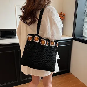Detailed macro view of black crochet tote bag featuring colorful sunflower embroidery trim