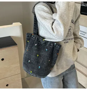 Détail du sac cabas en denim délavé gris foncé avec des broderies de tulipes colorées