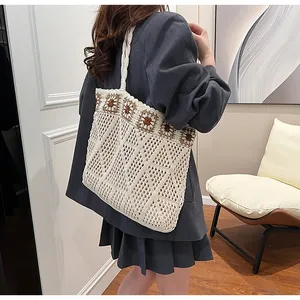Detailed knit tote bag with sunflower crochet patterns shown on a model's shoulder
