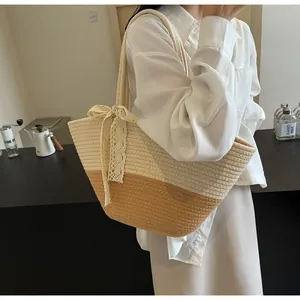 Detail of hand-woven straw tote bag with color-block design and cream lace bow accent