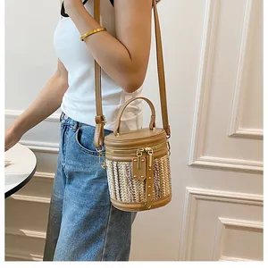 Detail of a woven bucket bag with leather top handle and gold zipper for summer vacation