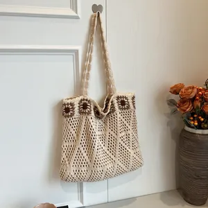 Close-up of bohemian hollow-out crochet tote bag with brown floral knit detailing