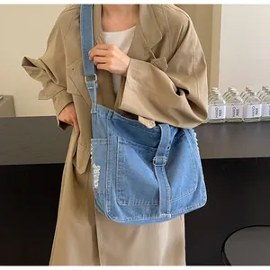 Detail einer blauen gewaschenen Jeans-Einkaufstasche mit Fransen und Metallschnalle