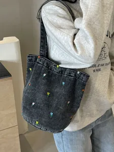 Grand sac cabas en jean noir délavé avec broderie tulipe porté par un mannequin