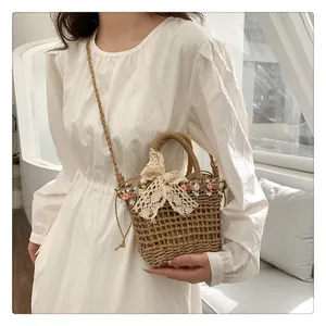 Detailed shot of straw bucket bag with floral lace bow and woven shoulder strap