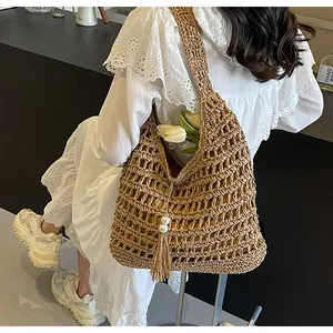 Détail du sac à bandoulière en paille bohème avec maille crochetée et pendentif perle