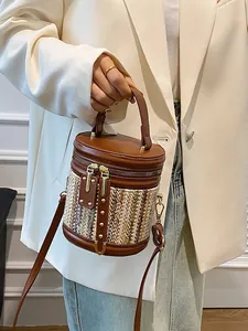 Chic brown leather and beige woven cylinder bucket bag with top handle and strap