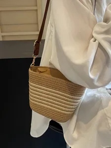 Fashionable striped woven crossbody beach bag with adjustable leather strap and gold hardware
