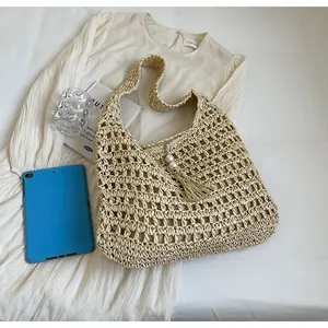 Détail du sac bohème en paille avec texture maille ajourée, franges et grandes perles