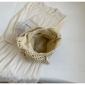 Détail de l'intérieur du sac en paille montrant la doublure et la poche zippée