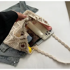 Detail showing the large capacity of a cream knit tote bag with floral patterns