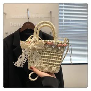Detail of hand-woven straw bag with pink satin roses and cream lace bow accents