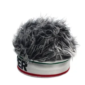 Macro detail of knit beanie featuring grey fuzzy wig fibers and red striped edge with ER logo