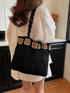 Black knit crochet tote bag with sunflower pattern trim and a spacious woven handle