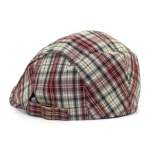 Detail of red and black plaid beret showing the textured fabric and back stitching