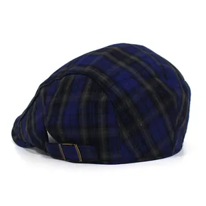 Detail view of the vintage plaid beret featuring a bronze metal adjustable buckle on the back