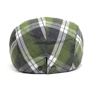 Close-up of olive green plaid ivy cap featuring twill fabric and metal adjustment buckle