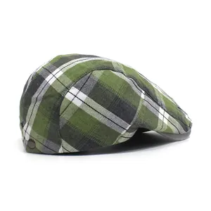 Detail of green plaid flat cap featuring a decorative vintage metal side button