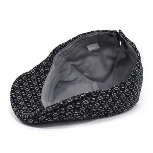Black and white textured cotton newsboy cap with 100% cotton label on white background