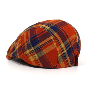 Detail shot of vintage plaid beret with orange and blue patterns and metal side buckle