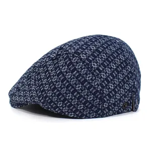 Detailed side view of navy denim jacquard ivy cap with geometric patterns and metal eyelets