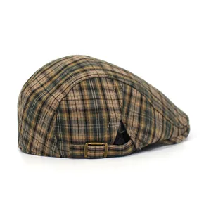 Close-up of vintage plaid flat cap featuring a bronze adjustable metal side buckle