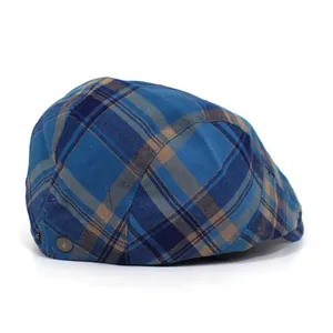 Detail of blue plaid flat cap featuring a metallic round button and retro British pattern