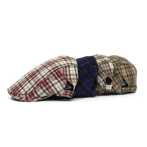Detail view of plaid newsboy caps with metal buckles and durable twill fabric