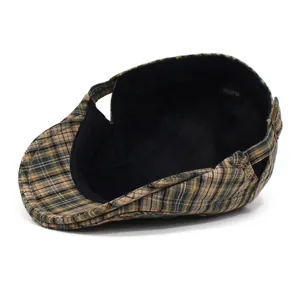 Detail view of cotton plaid newsboy cap with adjustable buckle and cotton label