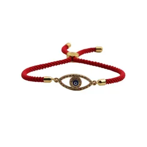 Detail of red braided evil eye bracelet with micro-pave crystals and adjustable knot